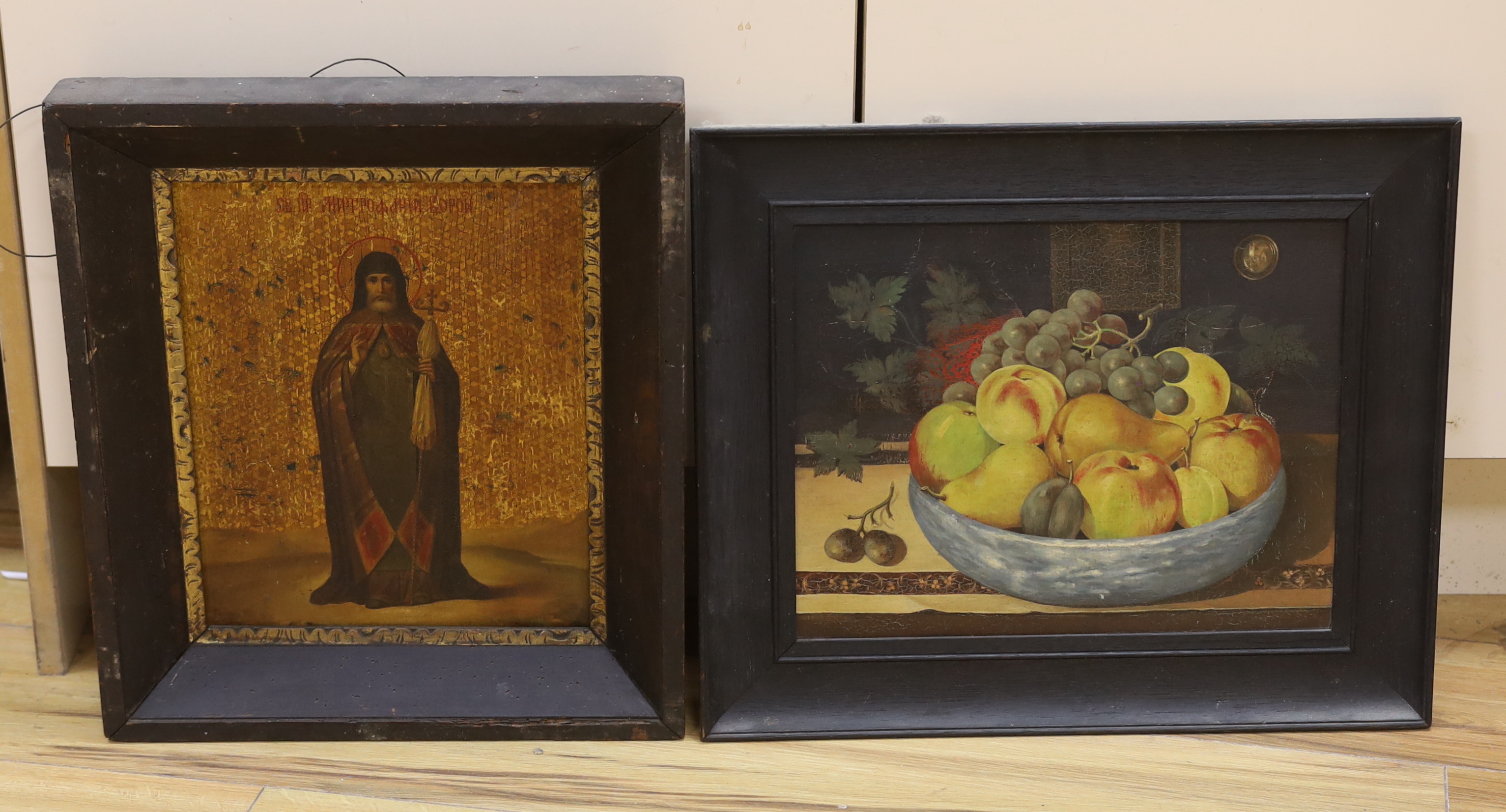 19th century Russian school, Icon, housed in an ebonised frame, together with a 17th century style, Dutch oil on board, Still life of fruit, largest 26 x 33cm